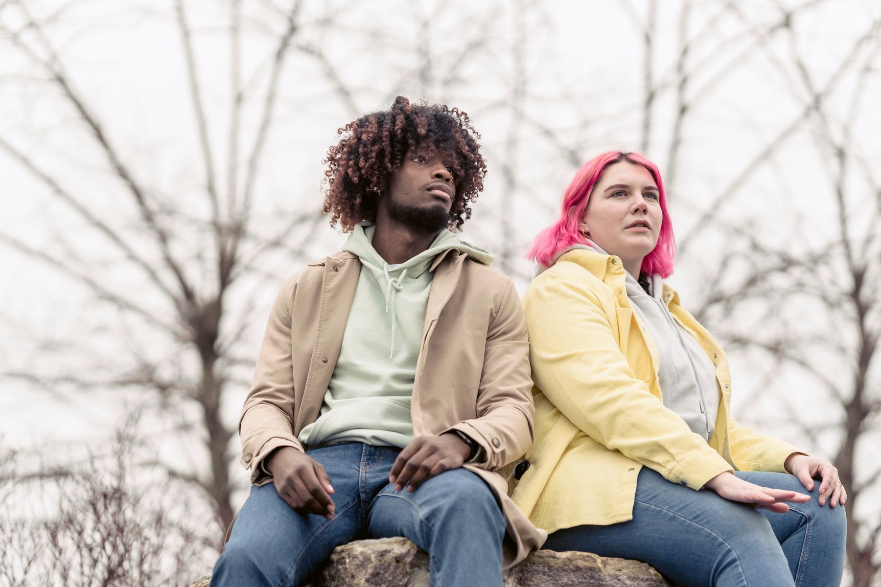 Couple sitting together on a rock outdoors