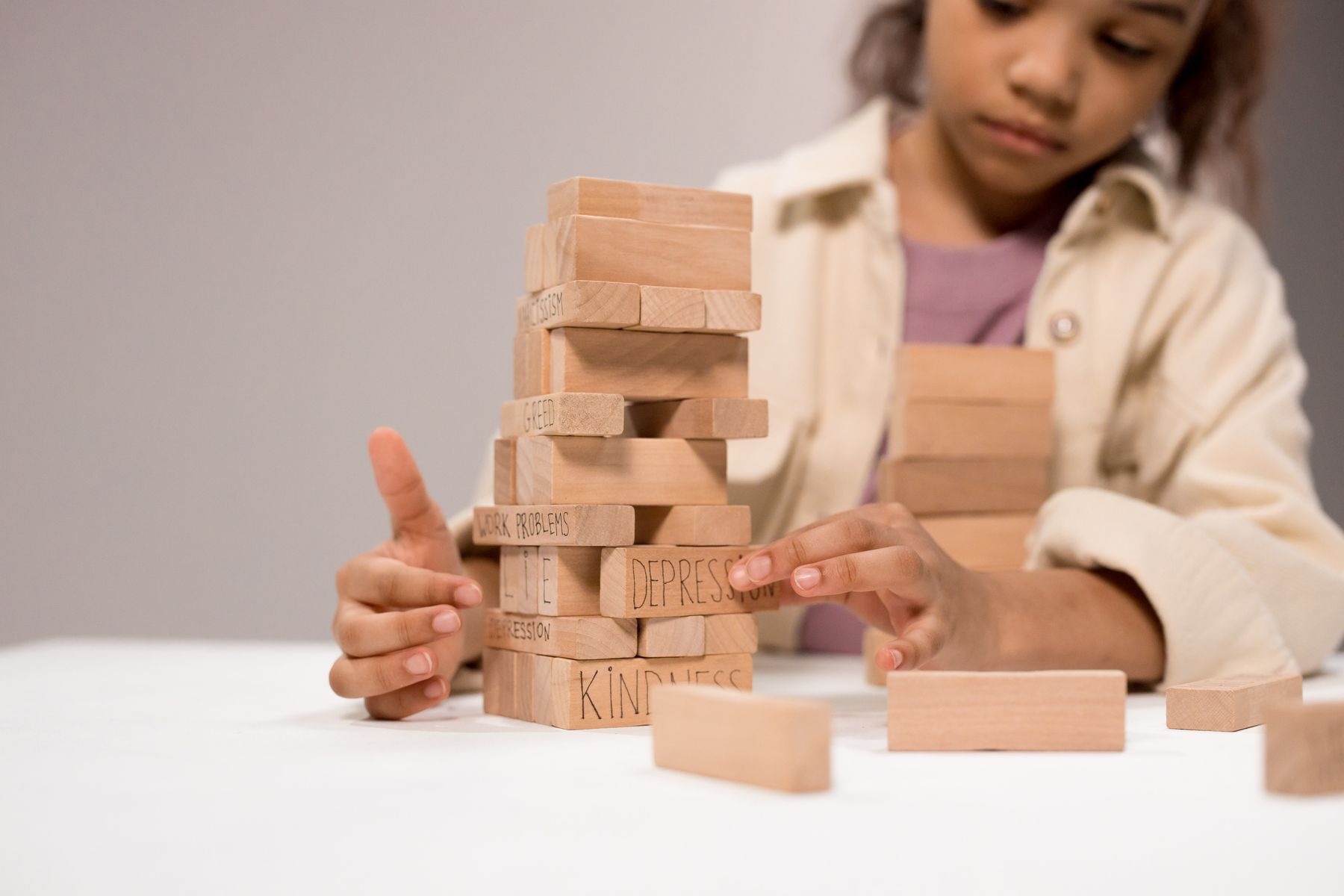 Child carefully stacking wooden blocks during play