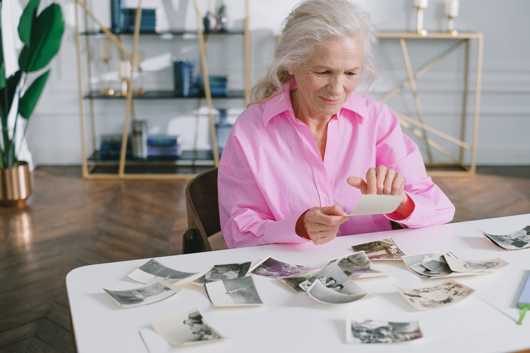 Older woman looking through old photographs at home