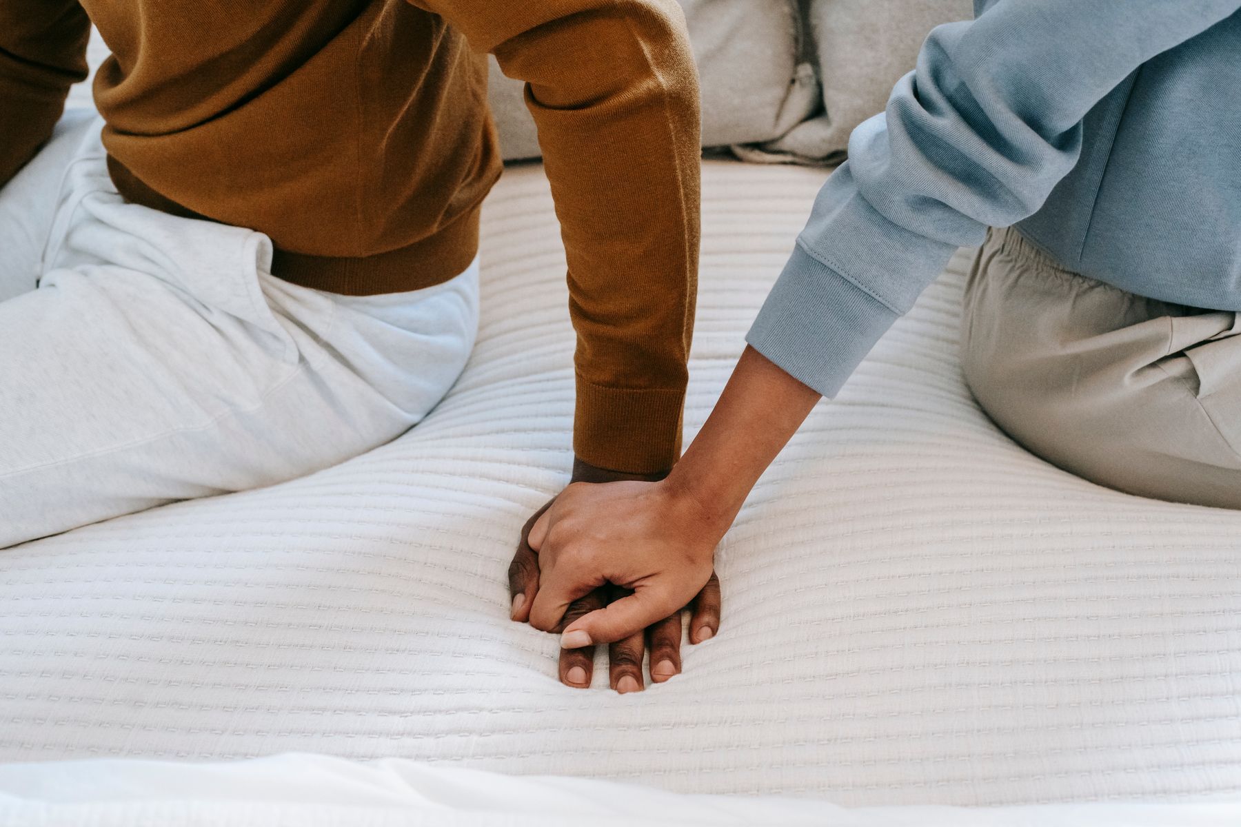Two people holding hands, a gesture of support