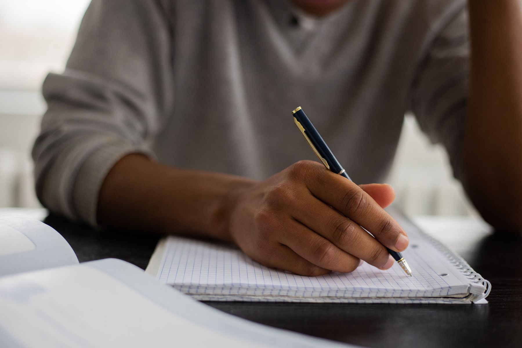Person writing notes in a notebook