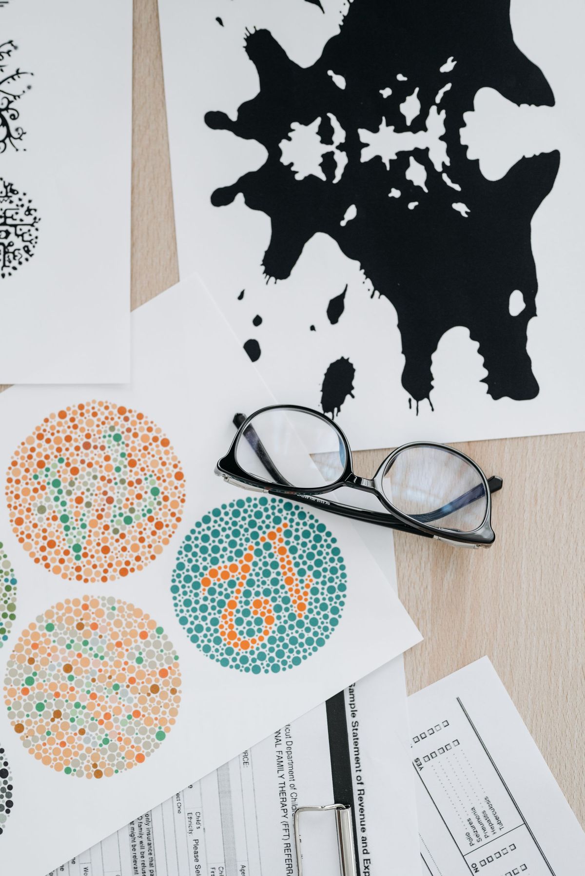 Eyeglasses resting on color vision and inkblot cards