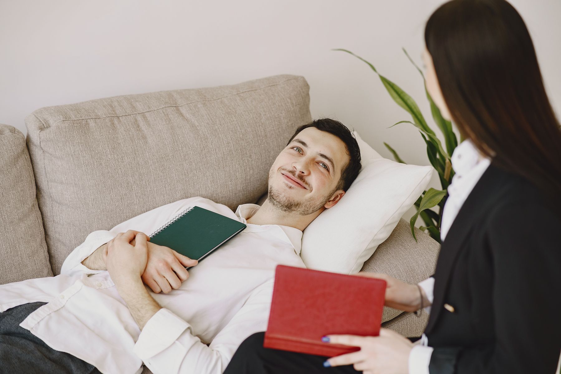 Man relaxing on a sofa and talking with a therapist